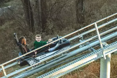 Mother and son riding The Wild Stallion mountain coaster