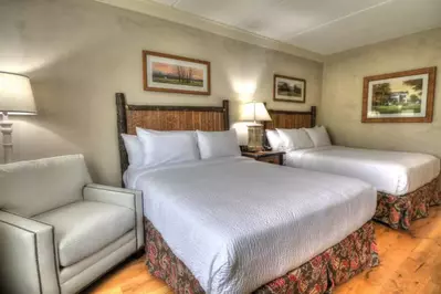A beautiful room with two Queen beds at The Lodge at Five Oaks.